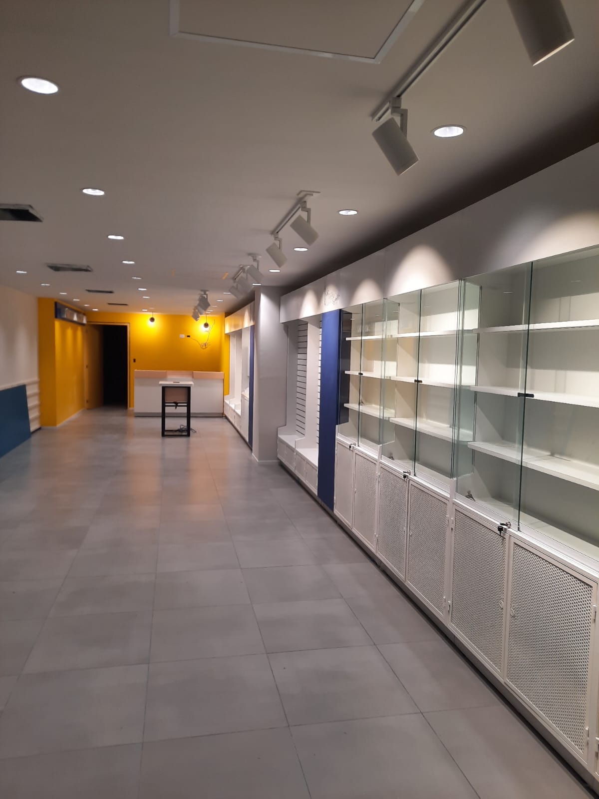 Vitrinas y anaqueles para tienda en acabado blanco con cristal, proyecto comercial en la Riviera Maya